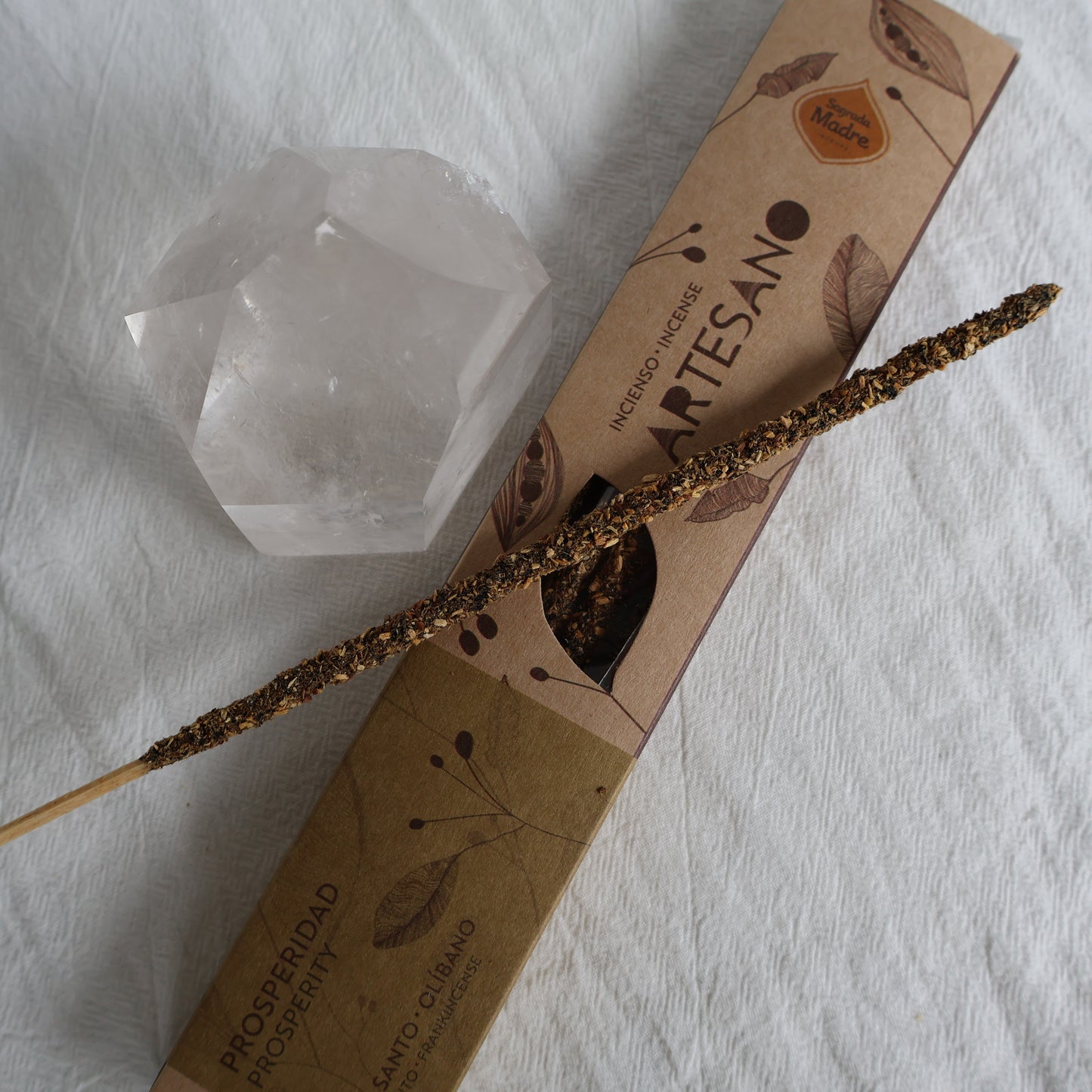 Artisanal product with a stick and crystal on a white fabric background