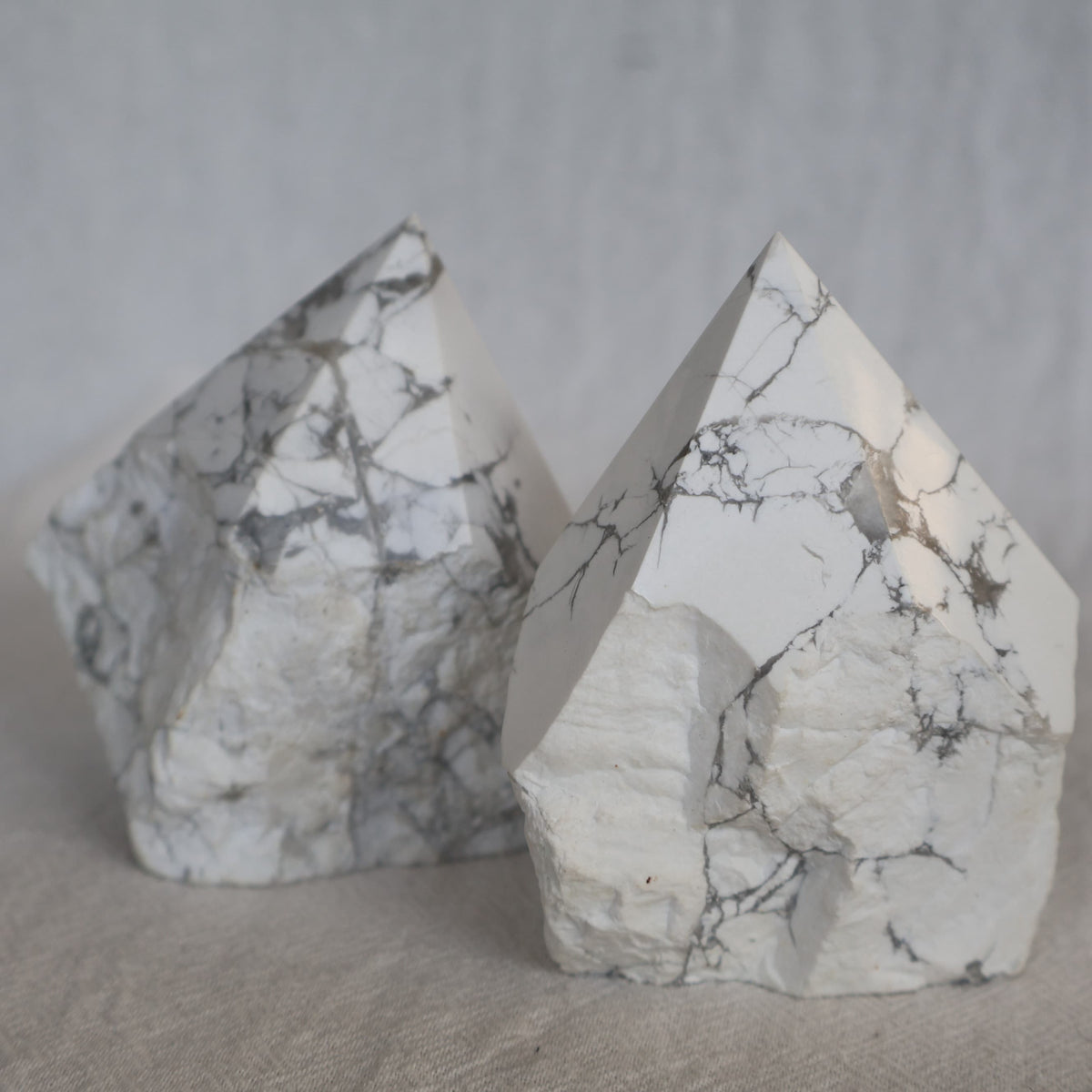 Howlite polished crystal point with classic white colouring and natural grey veining, approximately 7–8cm tall.