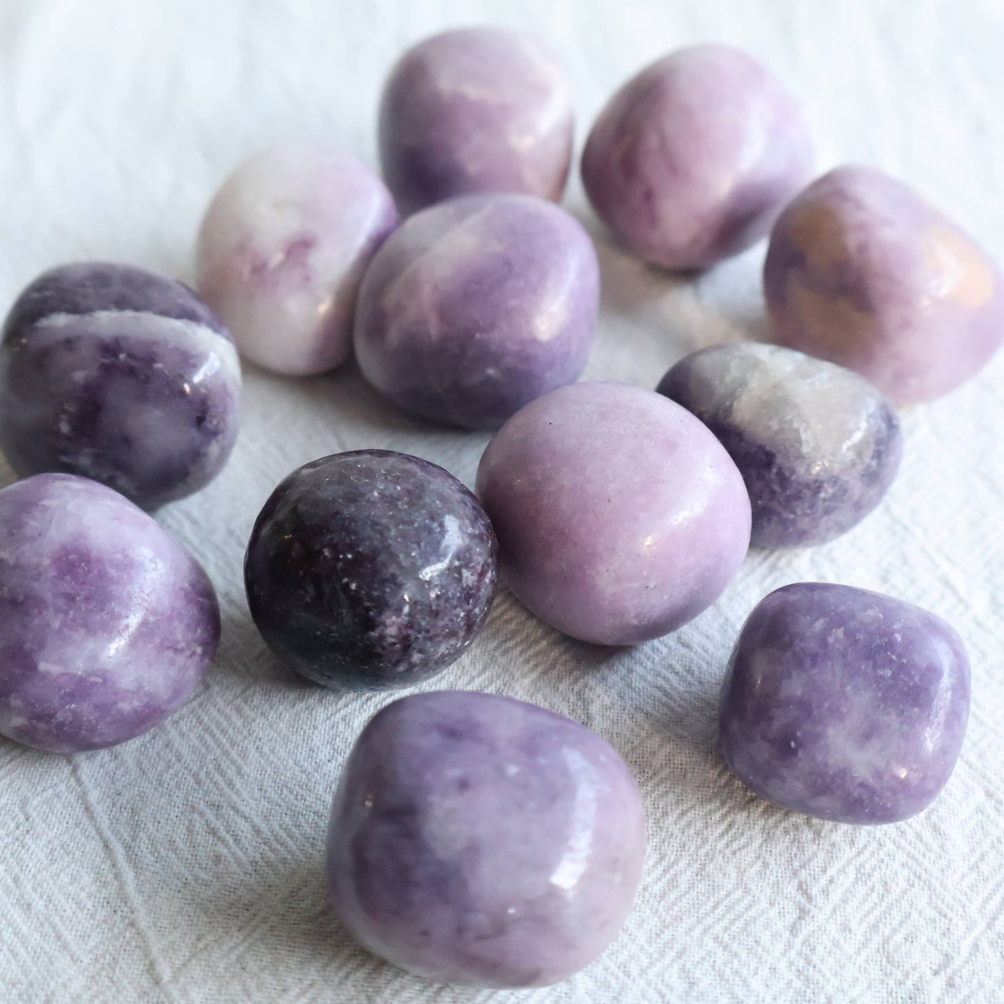 Polished Lepidolite crystal tumble in natural lilac, purple and creamy white tones with unique patterning.