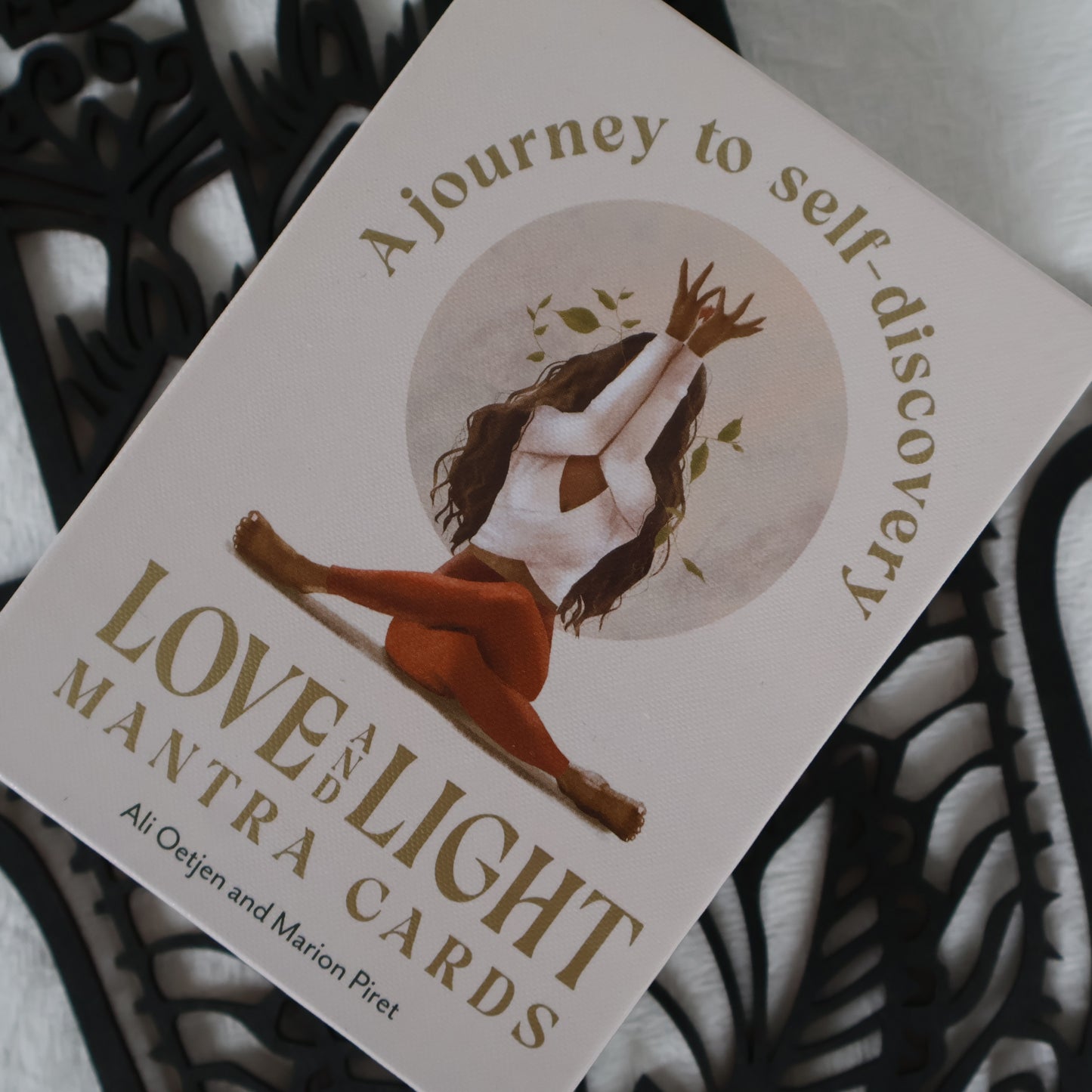 Card deck titled 'A Journey to Self-Discovery Love & Light Mantra Cards' with an illustration of a woman on a patterned surface.