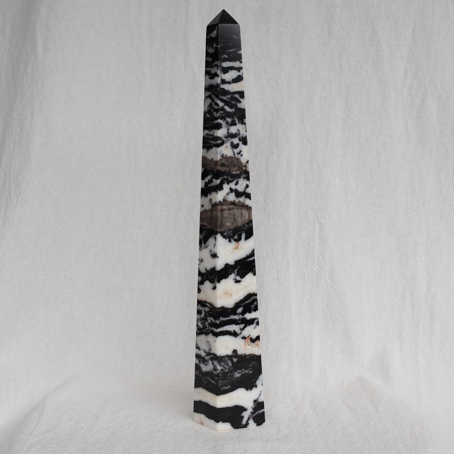 Large Zebra Jasper six-sided obelisk tower with bold natural black, white and grey patterning, standing 25cm tall and weighing 619g.