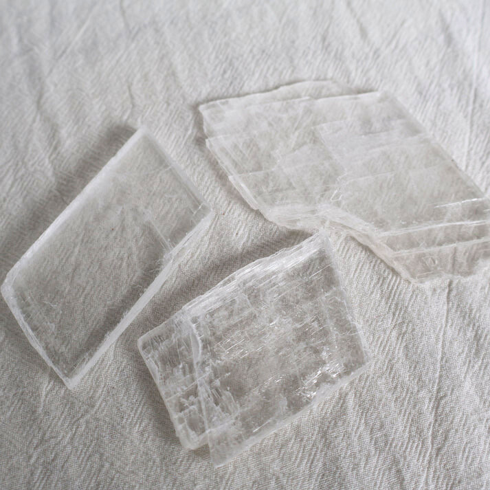 Three rectangular glass coasters on a textured gray surface