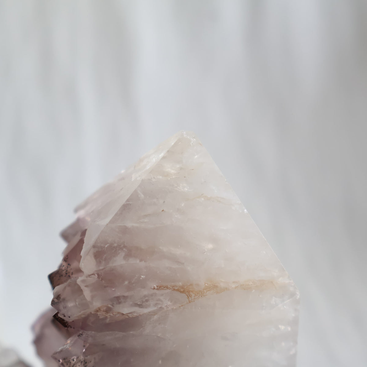 Amethyst polished point with exposed crystal clusters and dark mineral inclusions across the tips, measuring 13cm tall and weighing 778g.