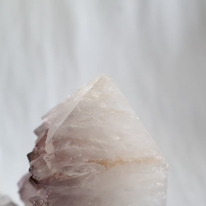 Amethyst polished point with exposed crystal clusters and dark mineral inclusions across the tips, measuring 13cm tall and weighing 778g.