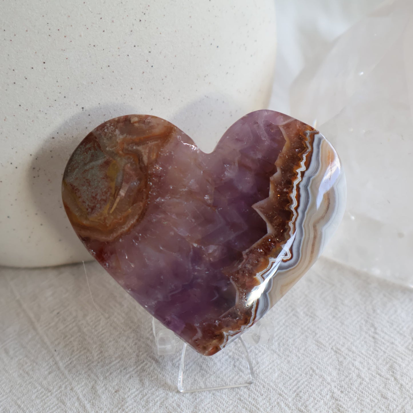 Amethyst Agate crystal heart with purple crystalline centre, brown and white natural banding and clear chair display stand.