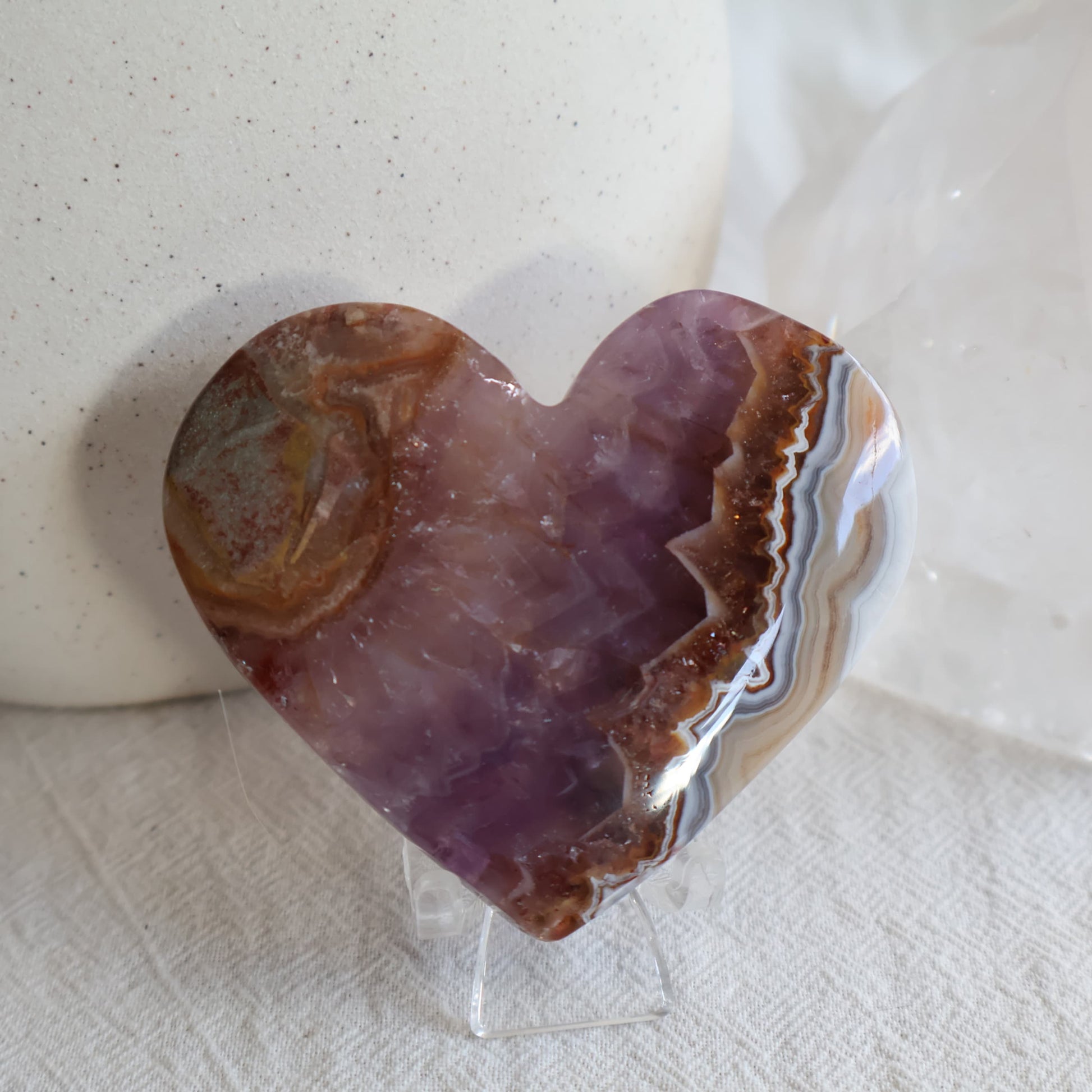 Amethyst Agate crystal heart with purple crystalline centre, brown and white natural banding and clear chair display stand.