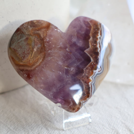 Amethyst Agate crystal heart with purple crystalline centre, brown and white natural banding and clear chair display stand.
