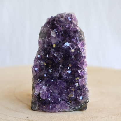 Small Amethyst cut base crystal formations with sparkling purple crystal clusters and freestanding polished base.