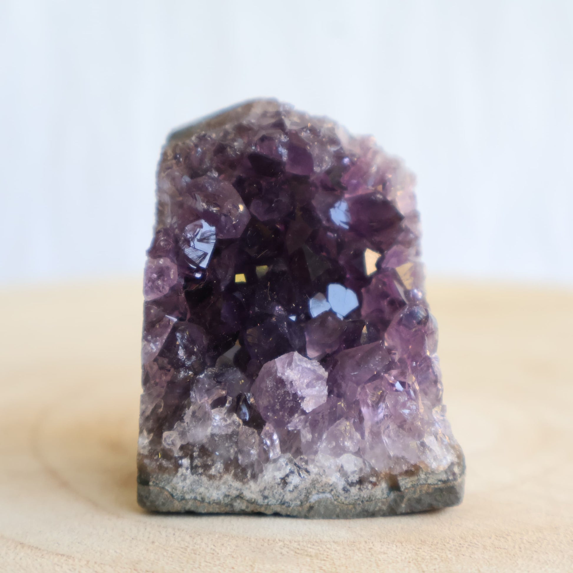 Small Amethyst cut base crystal formations with sparkling purple crystal clusters and freestanding polished base.