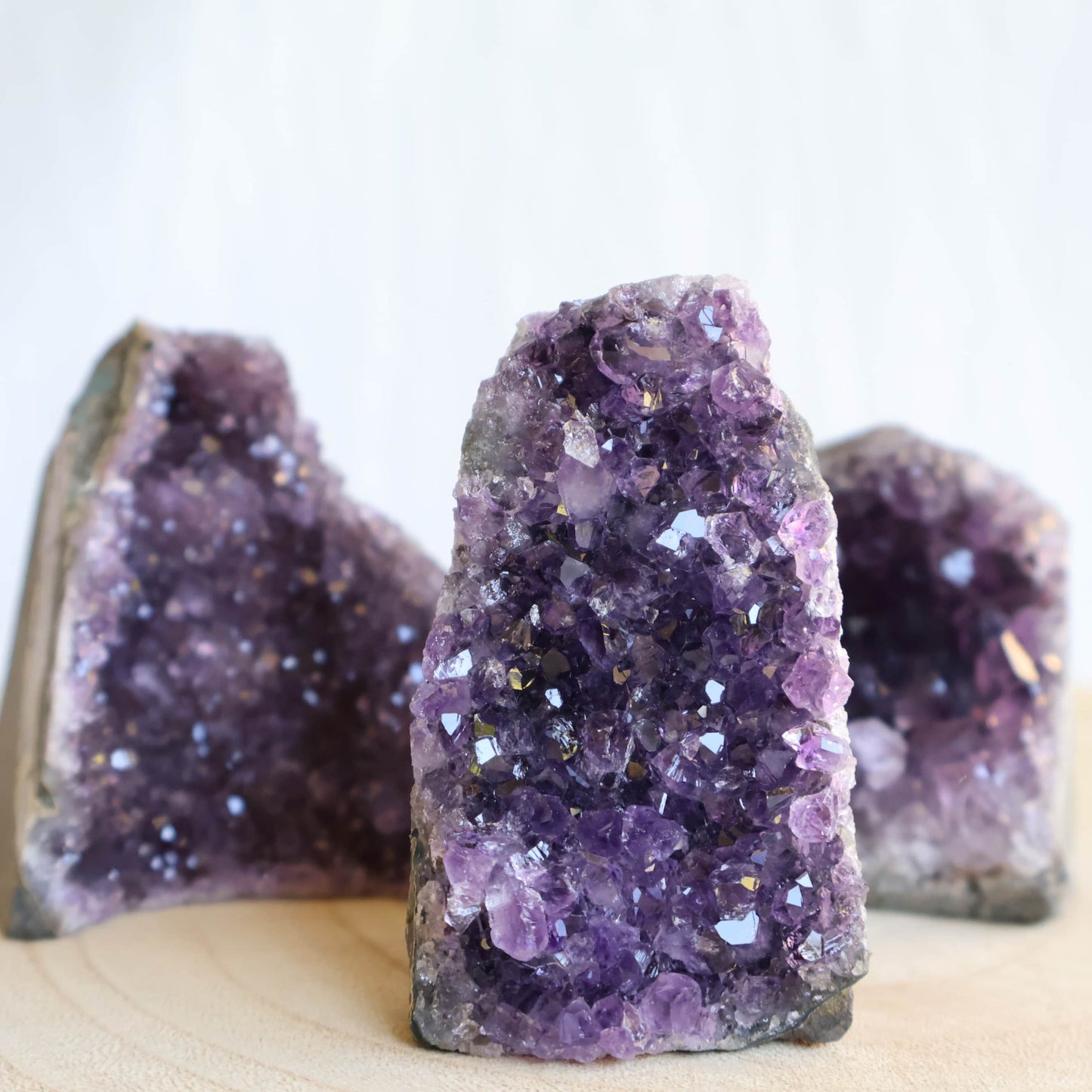 Small Amethyst cut base crystal formations with sparkling purple crystal clusters and freestanding polished base.