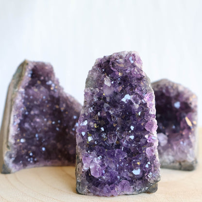 Small Amethyst cut base crystal formations with sparkling purple crystal clusters and freestanding polished base.