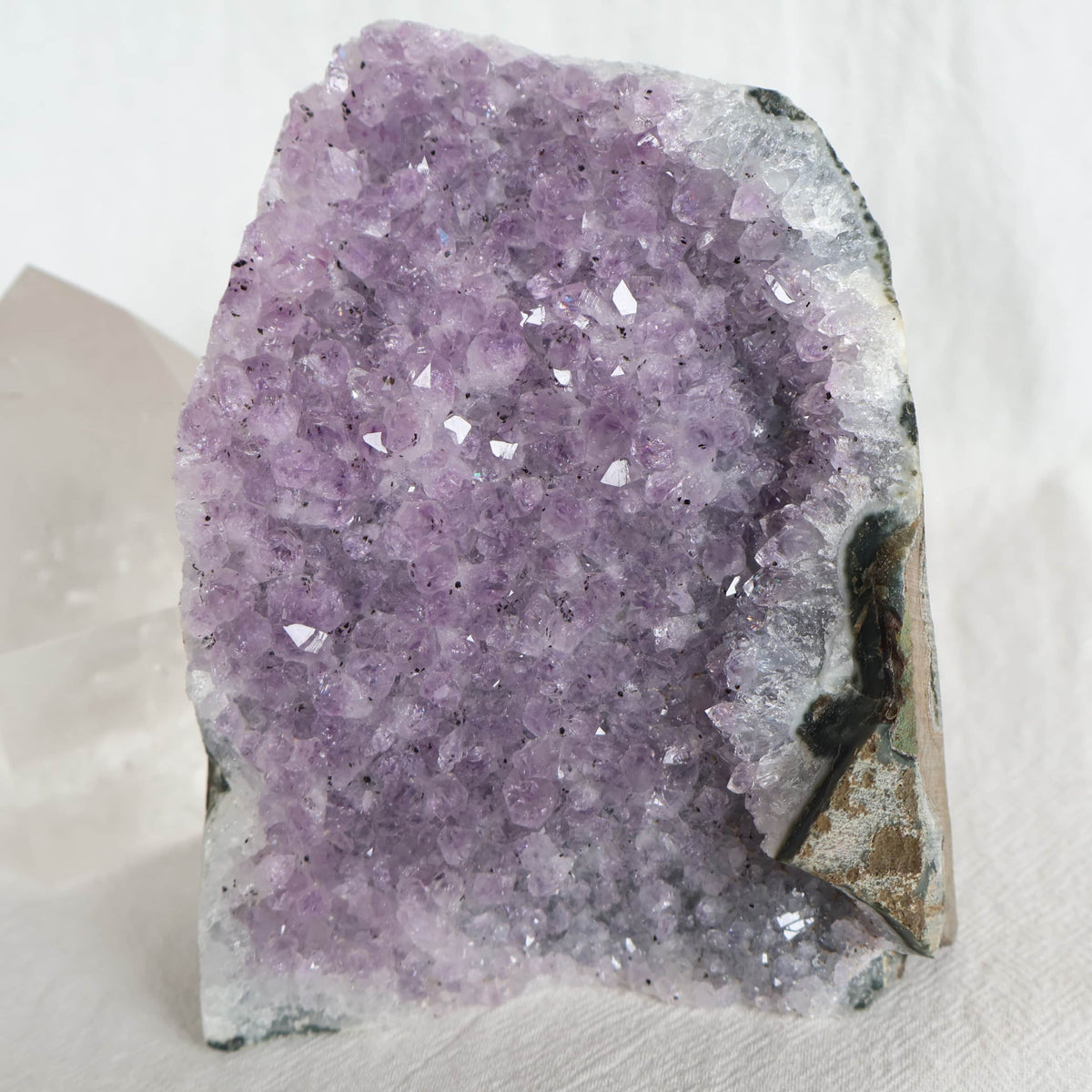 Natural Amethyst druzy cut base weighing 998g with purple crystal points and raw outer edges, standing 11.5cm tall.