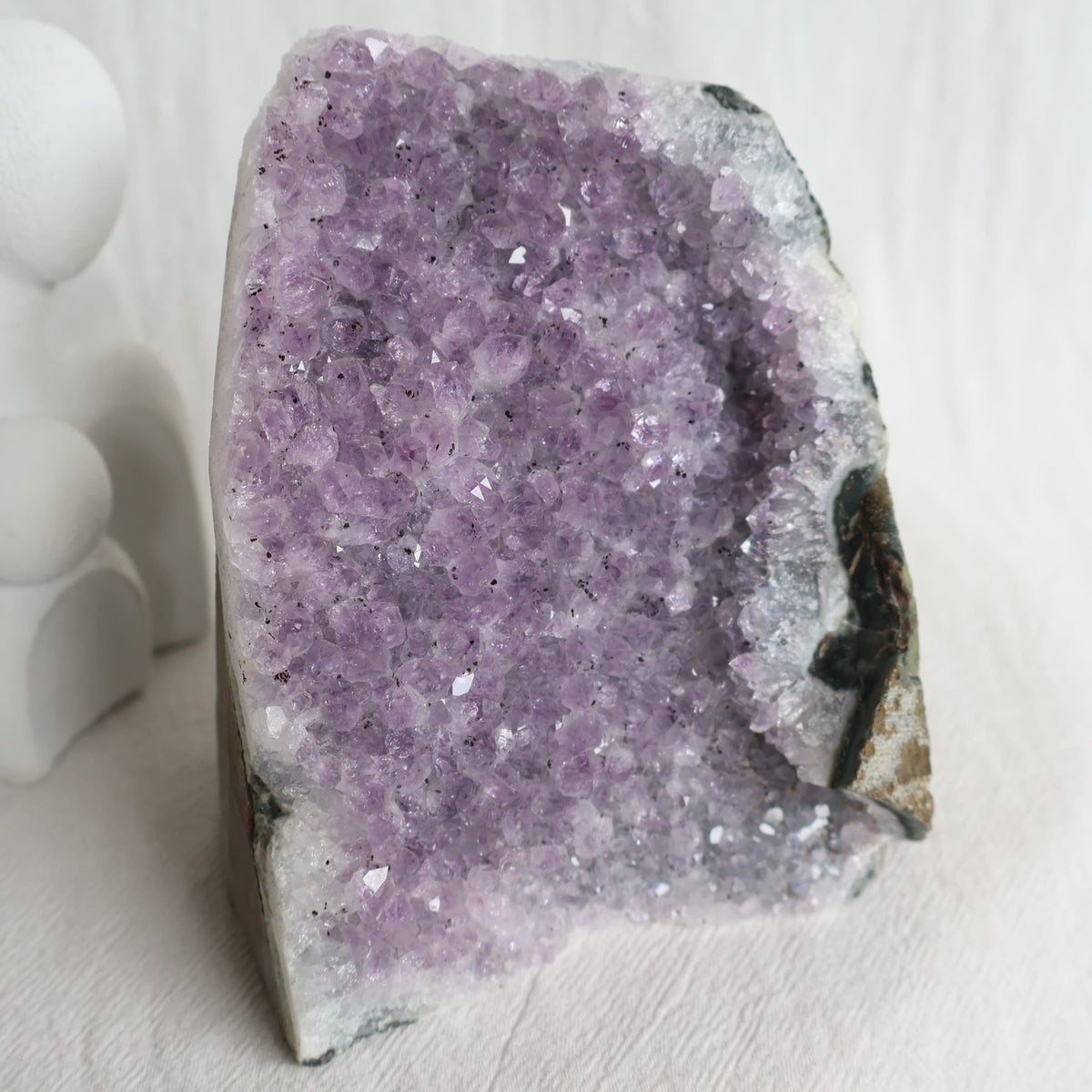 Natural Amethyst druzy cut base weighing 998g with purple crystal points and raw outer edges, standing 11.5cm tall.