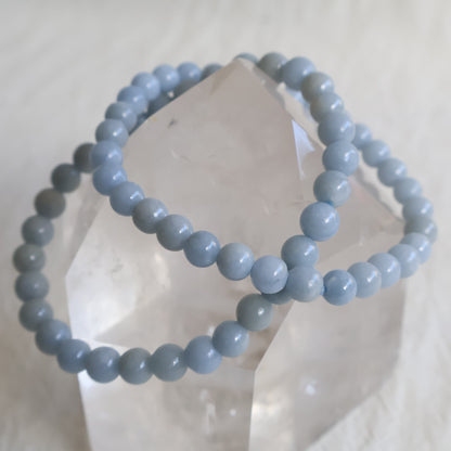 Natural Angelite 6mm crystal bead bracelet in soft sky blue tones with a smooth polished finish on a stretch cord.
