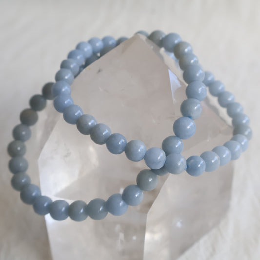 Natural Angelite 6mm crystal bead bracelet in soft sky blue tones with a smooth polished finish on a stretch cord.