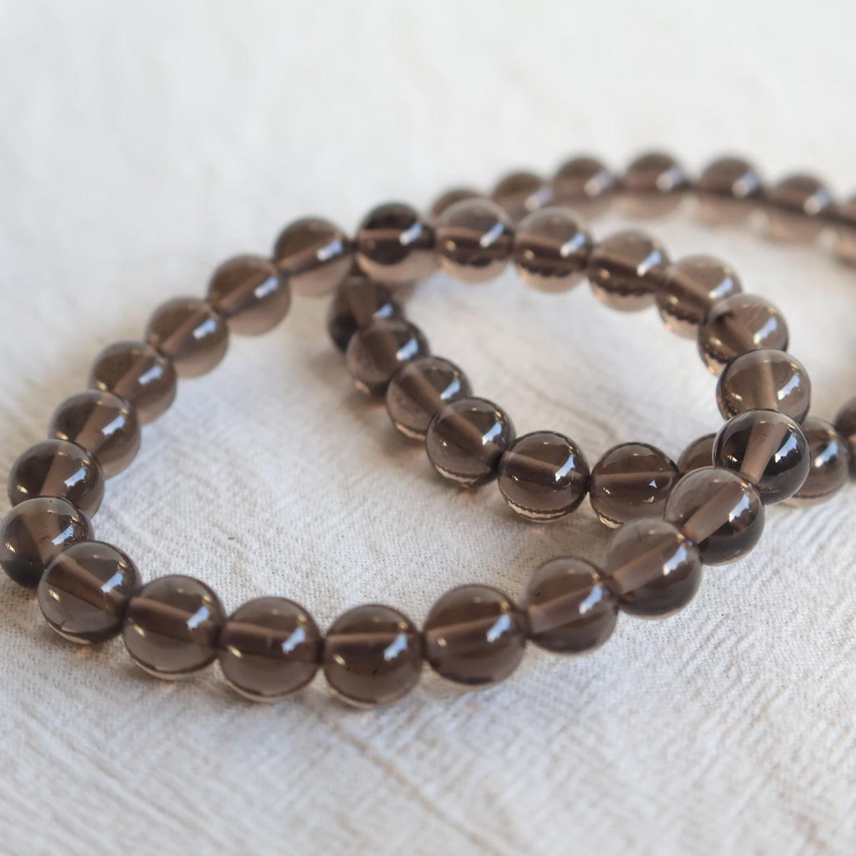 Apache Tear crystal bracelet with polished 8mm round beads on a stretch fit band.