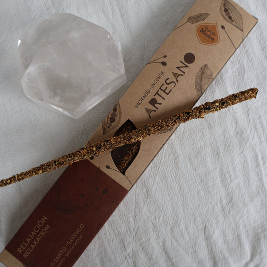 Artisanal incense stick with packaging and a crystal on a white surface