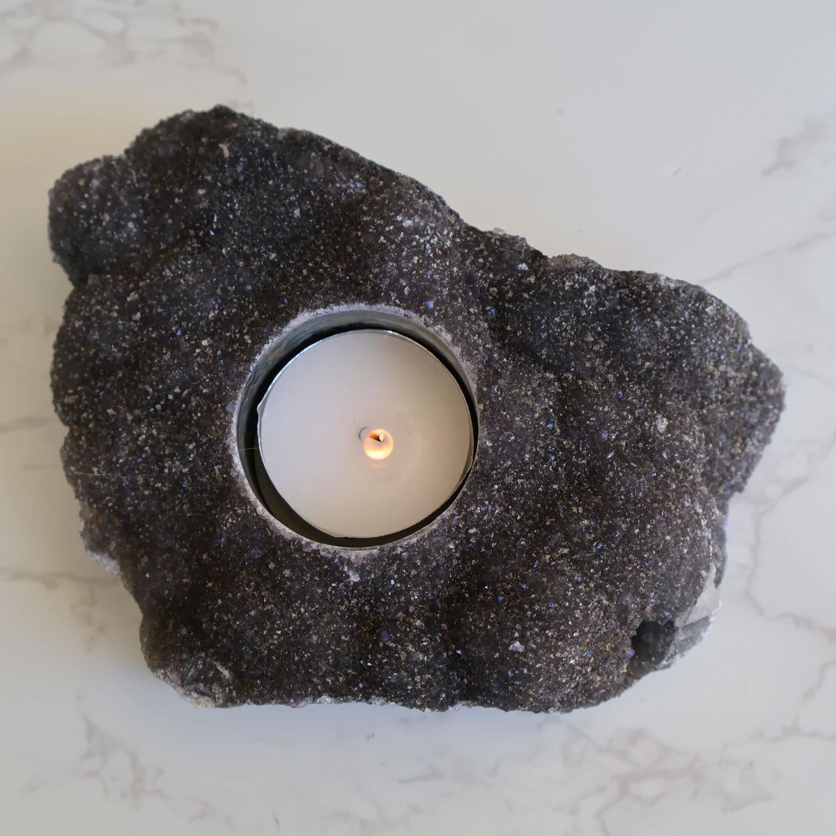 Black Amethyst tealight candle holder, 14cm long and 586g, with a dark natural druzy crystal surface and carved candle opening.