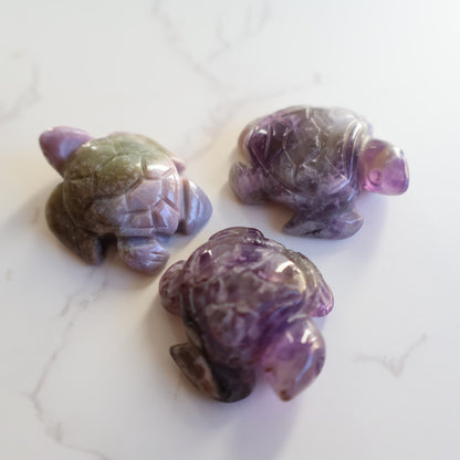 Mini crystal turtle carvings in Dream Amethyst, Green Aventurine and Tiger's Eye with polished finish and detailed shell carving.