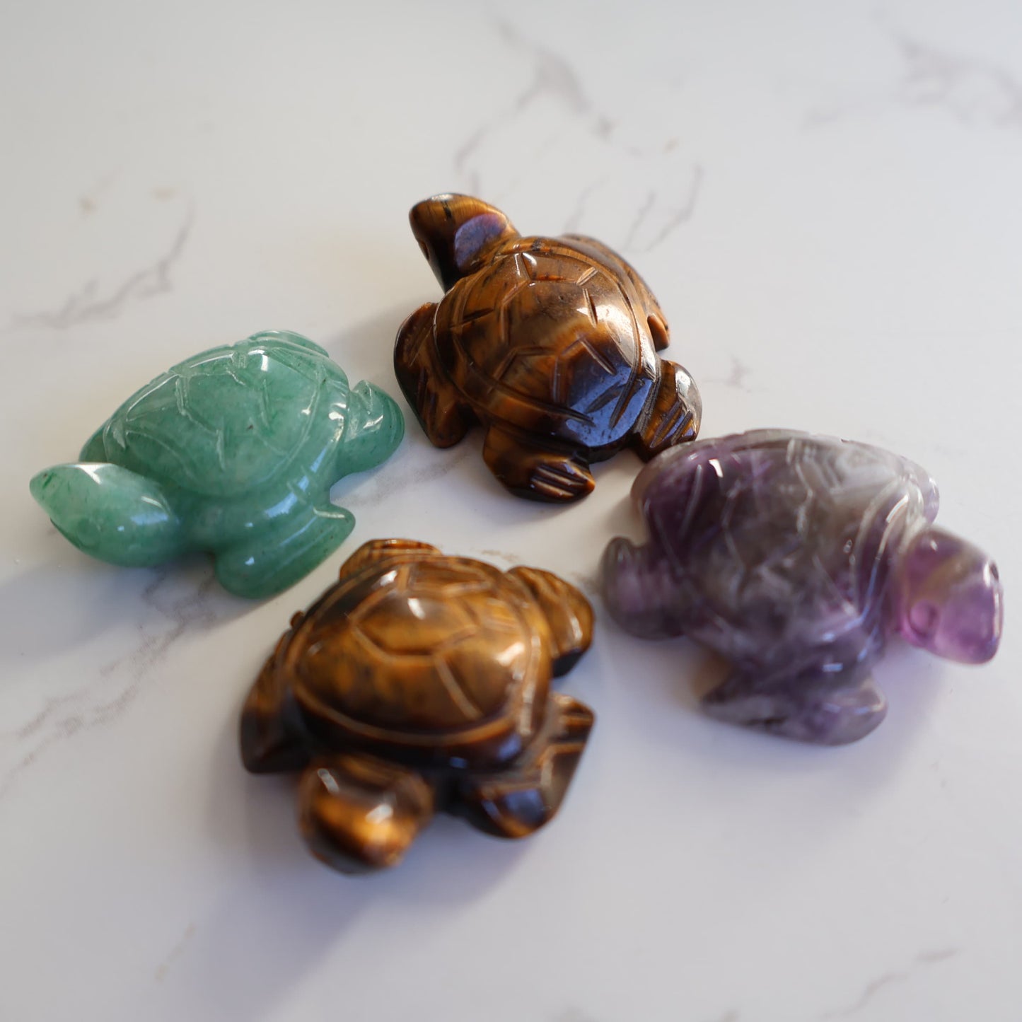 Mini crystal turtle carvings in Dream Amethyst, Green Aventurine and Tiger's Eye with polished finish and detailed shell carving.