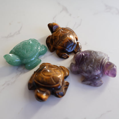 Mini crystal turtle carvings in Dream Amethyst, Green Aventurine and Tiger's Eye with polished finish and detailed shell carving.