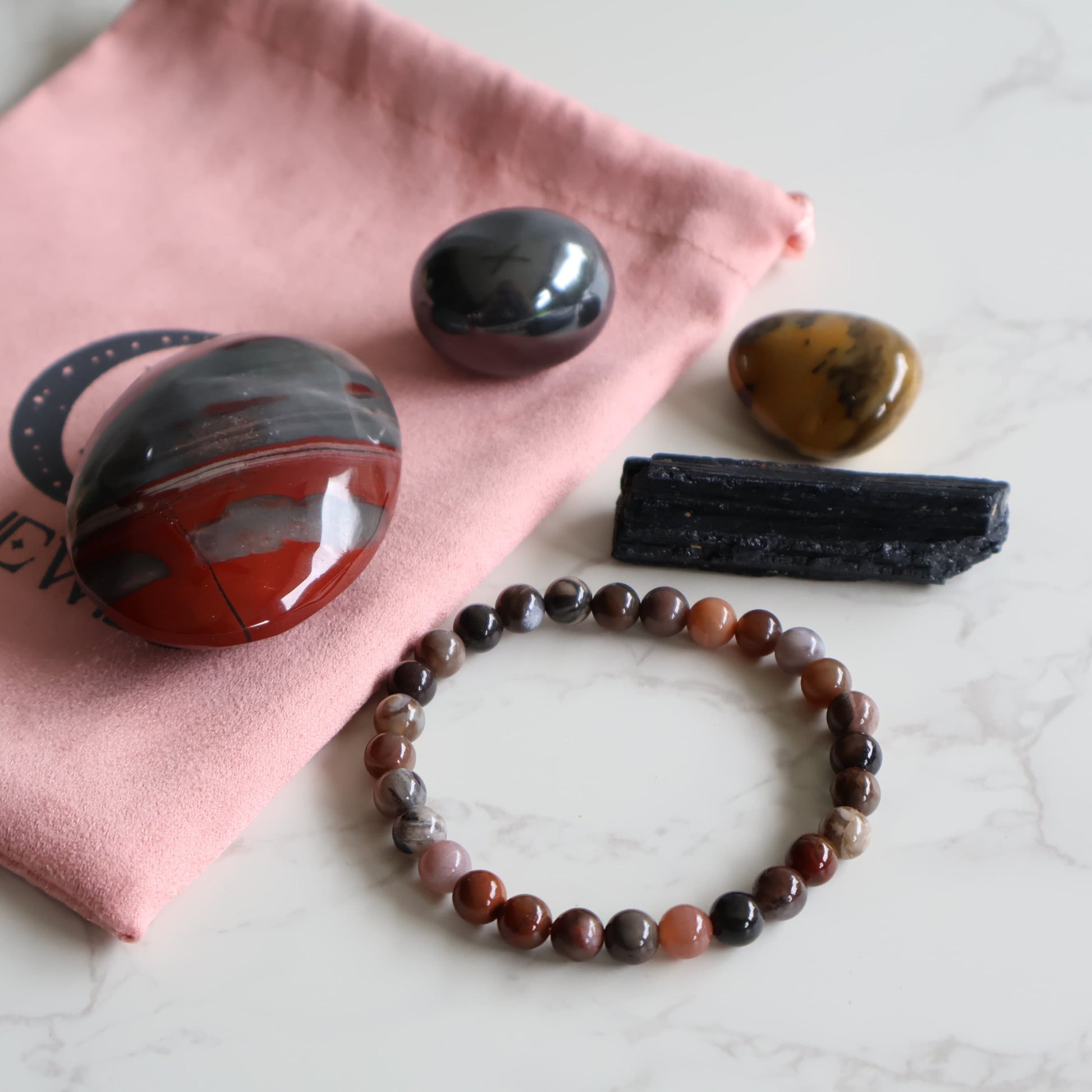 Grounding and stability ritual set with bloodstone palm black tourmaline raw mookaite tumble and petrified wood bracelet.