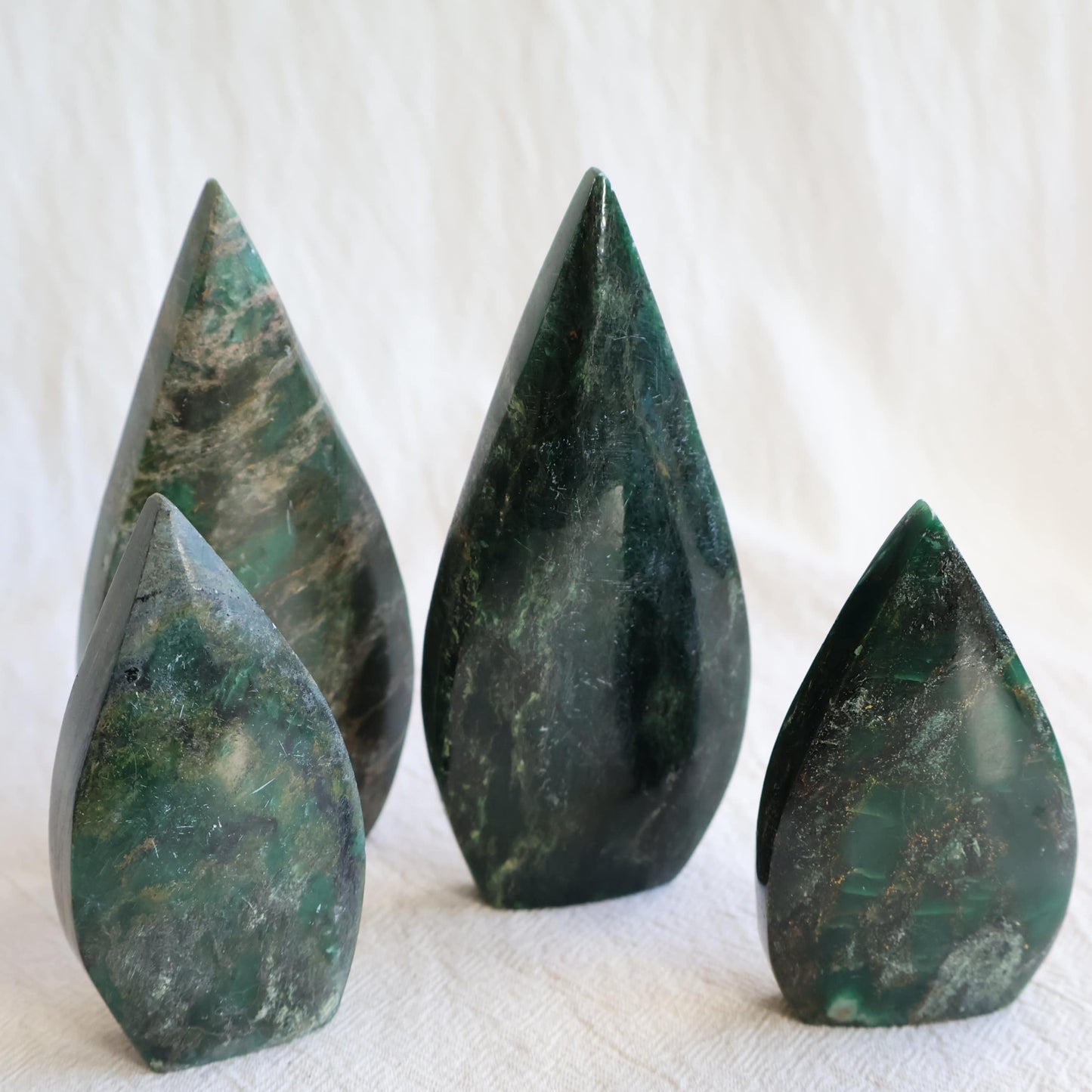Natural Emerald crystal freeforms with deep green colouring, earthy inclusions and polished modern freeform shapes.