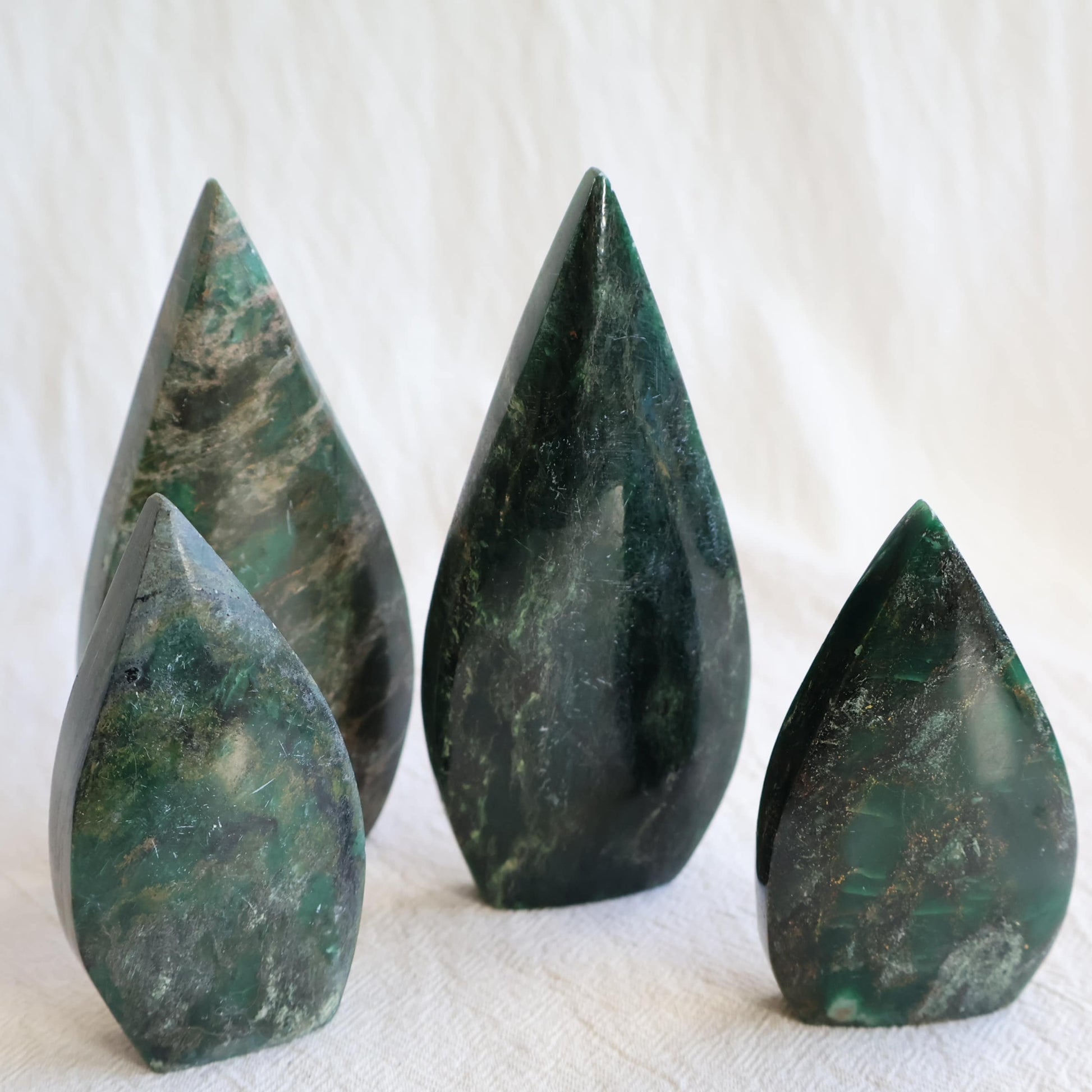 Natural Emerald crystal freeforms with deep green colouring, earthy inclusions and polished modern freeform shapes.