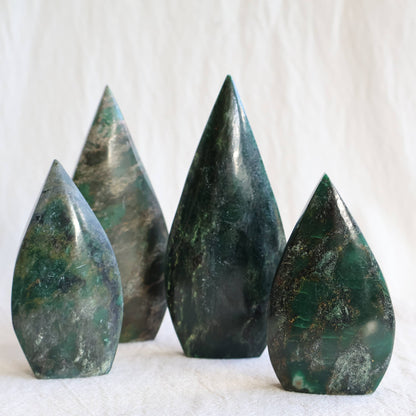 Natural Emerald crystal freeforms with deep green colouring, earthy inclusions and polished modern freeform shapes.