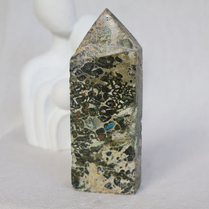 Epidote obelisk with natural Chrysocolla and copper inclusions, featuring earthy green, soft blue and metallic tones, 10.7cm tall.
