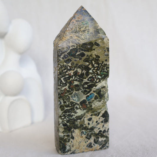 Epidote obelisk with natural Chrysocolla and copper inclusions, featuring earthy green, soft blue and metallic tones, 10.7cm tall.