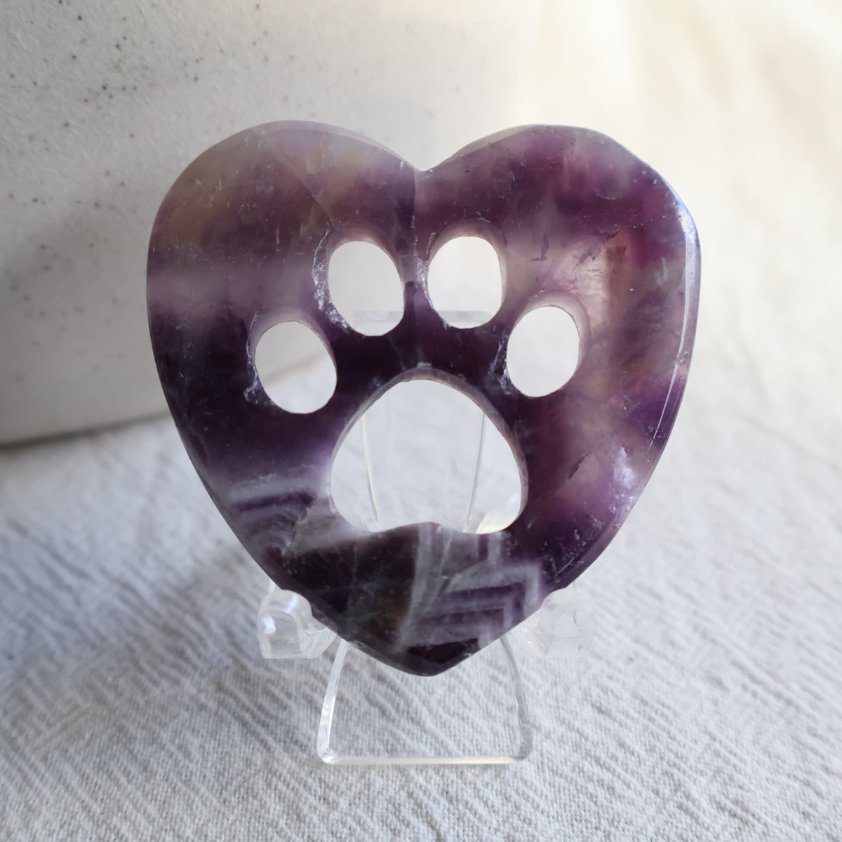 Crystal heart carvings with paw print cut-outs, available in Rose Quartz, Fluorite and Dream Amethyst.