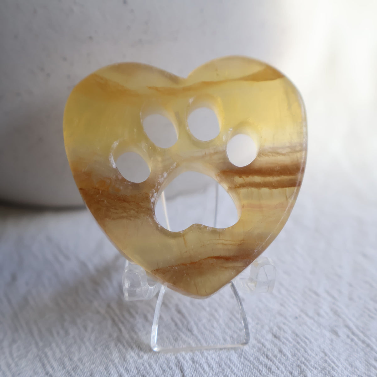 Crystal heart carvings with paw print cut-outs, available in Rose Quartz, Fluorite and Dream Amethyst.
