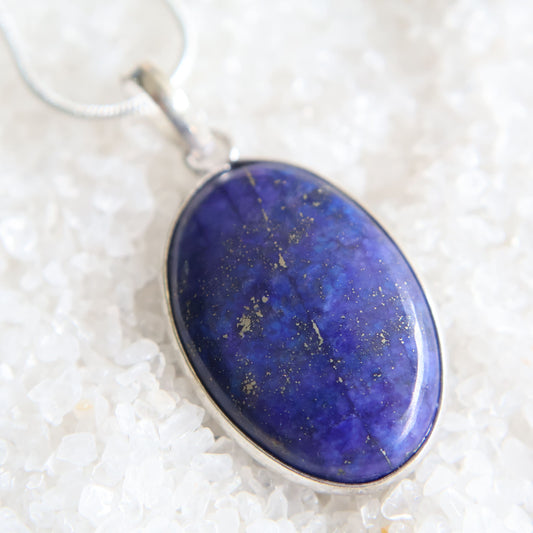 Lapis lazuli crystal pendant with deep blue colour and natural pyrite flecks, wrapped s925 silver border, exact piece shown
