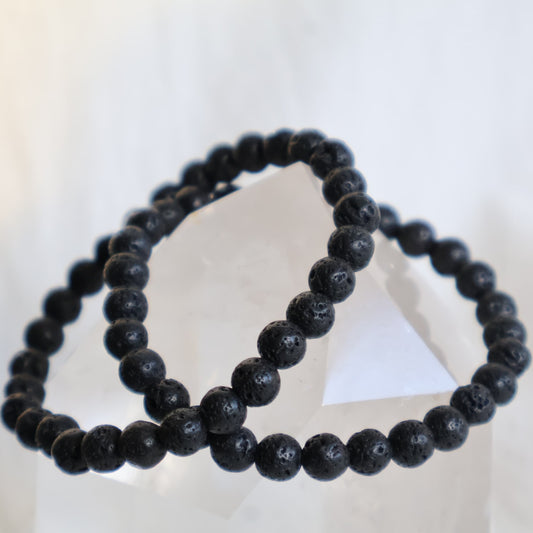 Lava Stone 6mm bead stretch bracelet with deep charcoal-black beads and a naturally porous volcanic texture.