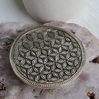 Decorative metal plate with geometric pattern on a textured surface