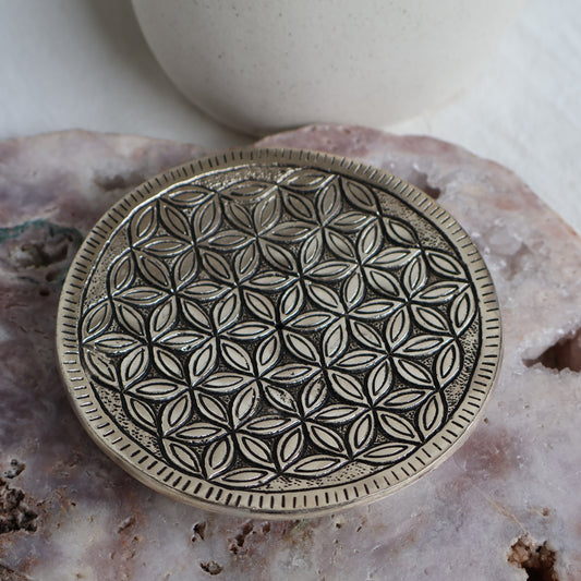 Decorative metal plate with geometric pattern on a textured surface