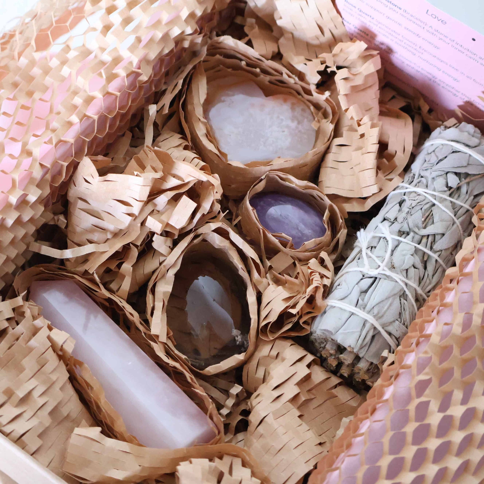 Love Within Valentine’s self love ritual set gift box with Rose Quartz generator, Flower Agate heart on stand, Smoky Quartz palm stone, Amethyst tumble, and sage bundle