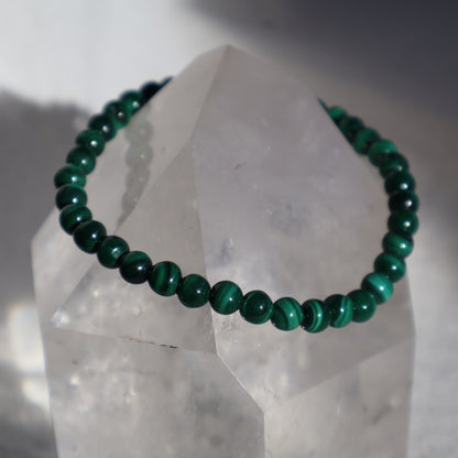 Malachite 4mm bead stretch bracelet with vibrant green beads and distinctive natural banding and swirling patterns.
