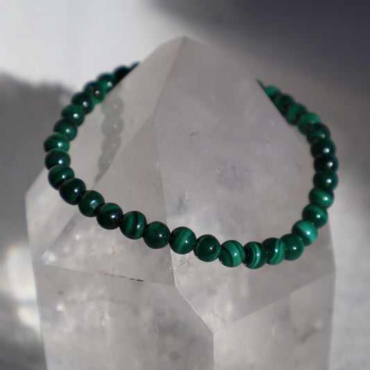 Malachite 4mm bead stretch bracelet with vibrant green beads and distinctive natural banding and swirling patterns.