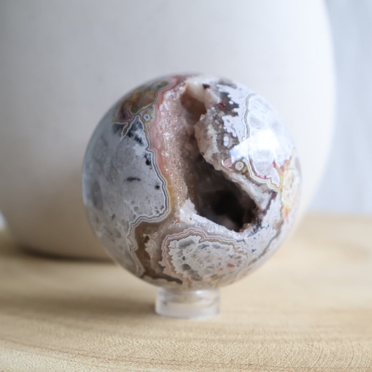 Crazy Lace Agate crystal sphere with natural banding and open druzy Quartz cavity, measuring 5cm and weighing 190g.
