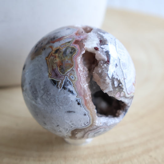 Crazy Lace Agate crystal sphere with natural banding and open druzy Quartz cavity, measuring 5cm and weighing 190g.