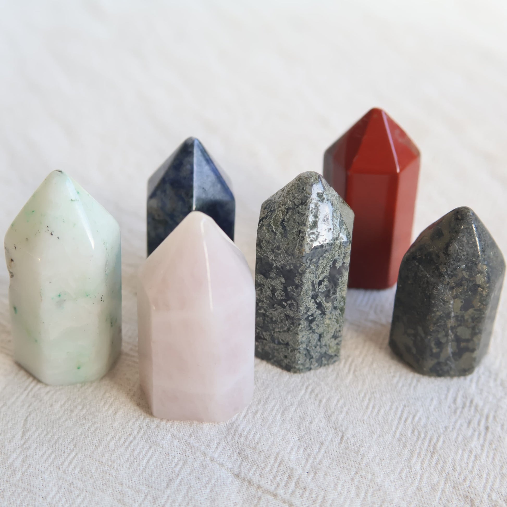 Collection of mini crystal generators available in Phoenix Stone, Rose Quartz, Pyrite, Moss Agate, and Sodalite with polished pointed tops and natural colour variations.