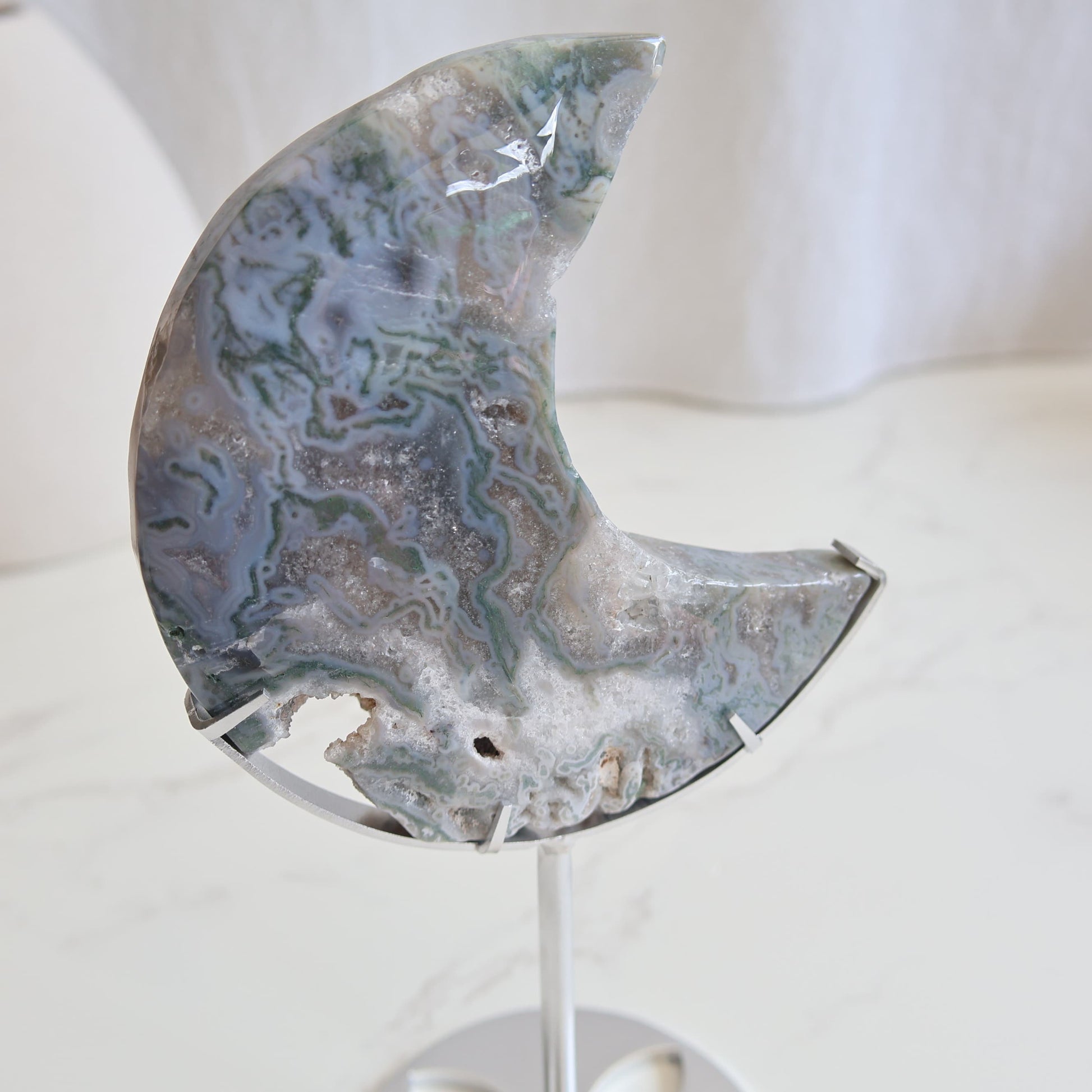Moss Agate moon carving on silver stand with green inclusions and natural patterns