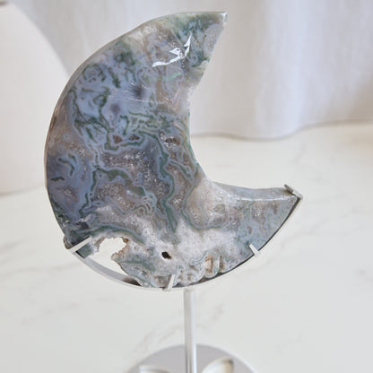 Moss Agate moon carving on silver stand with green inclusions and natural patterns