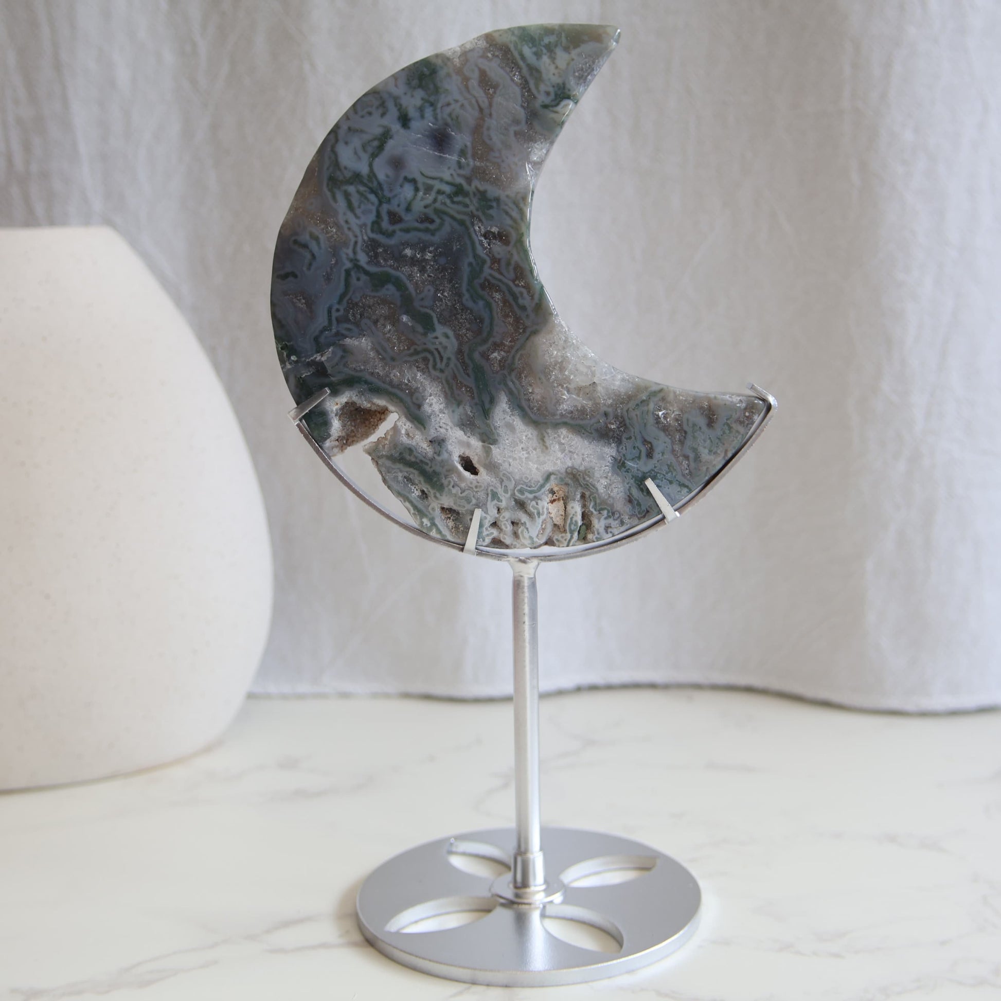 Moss Agate moon carving on silver stand with green inclusions and natural patterns