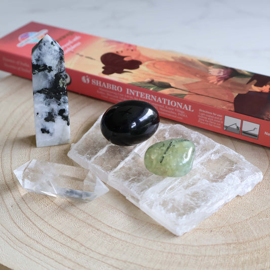 New moon ritual set with selenite slab clear quartz point rainbow moonstone obelisk prehnite black obsidian and incense in Stonewild drawstring bag.