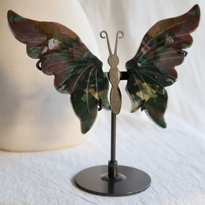 Ocean Jasper butterfly wings on black metal stand with deep green, burgundy, pink and cream natural patterning and polished carved detail