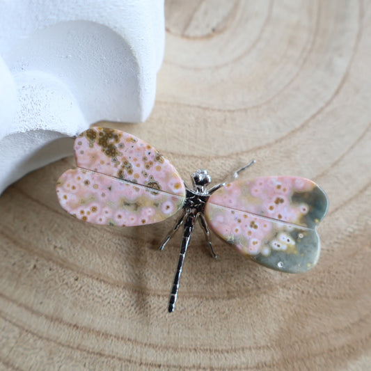 Ocean Jasper dragonfly carving, 6cm wide, with pink and green orbicular crystal wings and a silver-toned metal body.