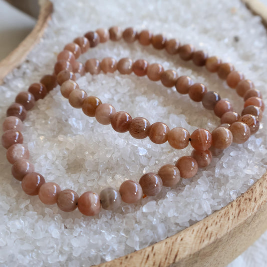 Natural Peach Moonstone 6mm crystal bead bracelet in soft peach and cream tones with a smooth polished finish on a stretch cord.